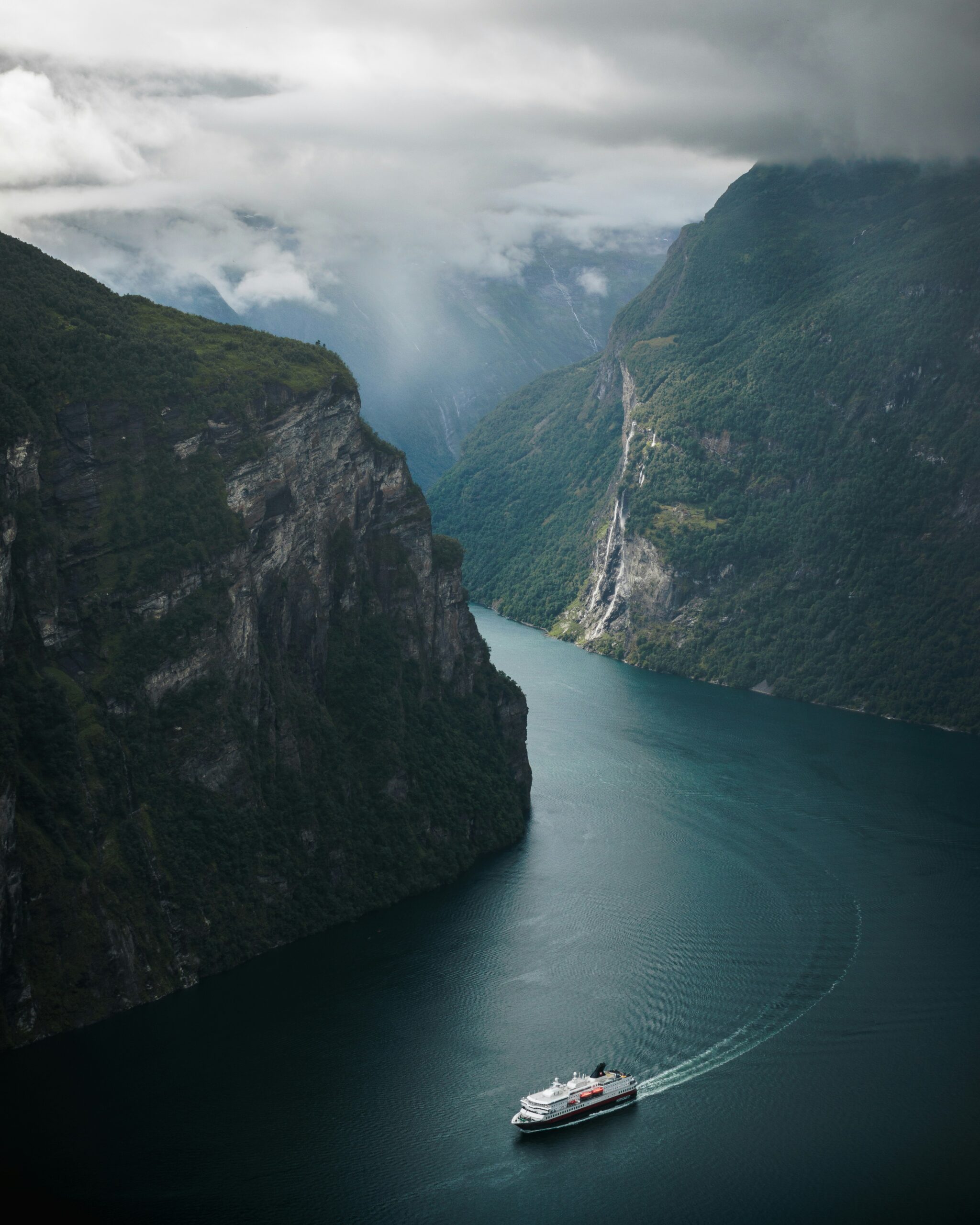 Deep blue waters and towering cliffs of Geirangerfjord, one of the most visually striking fjords in this Scandinavia Travel Guide.